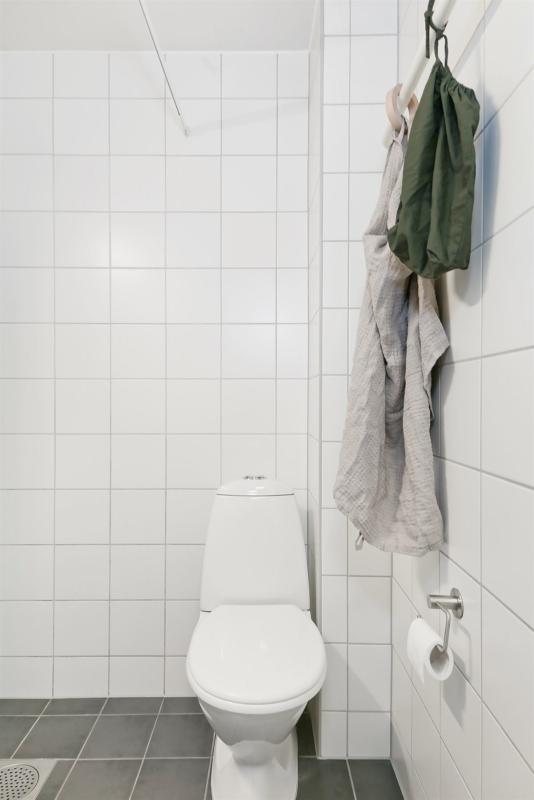 De grå flisene på gulv står i fin kontrast til de hvite veggflisene og passer inn med leilighetens gjennomgående lyse, behagelige fremtoning. Galleribilde