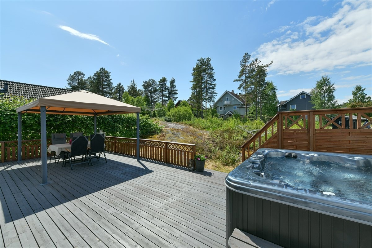Langs tre sider av boligen ligger er herlig terrasse på hele 103 kvm med mørkbeiset trebord, lysmalt rekkverk og trapp ned til hagen. Galleribilde