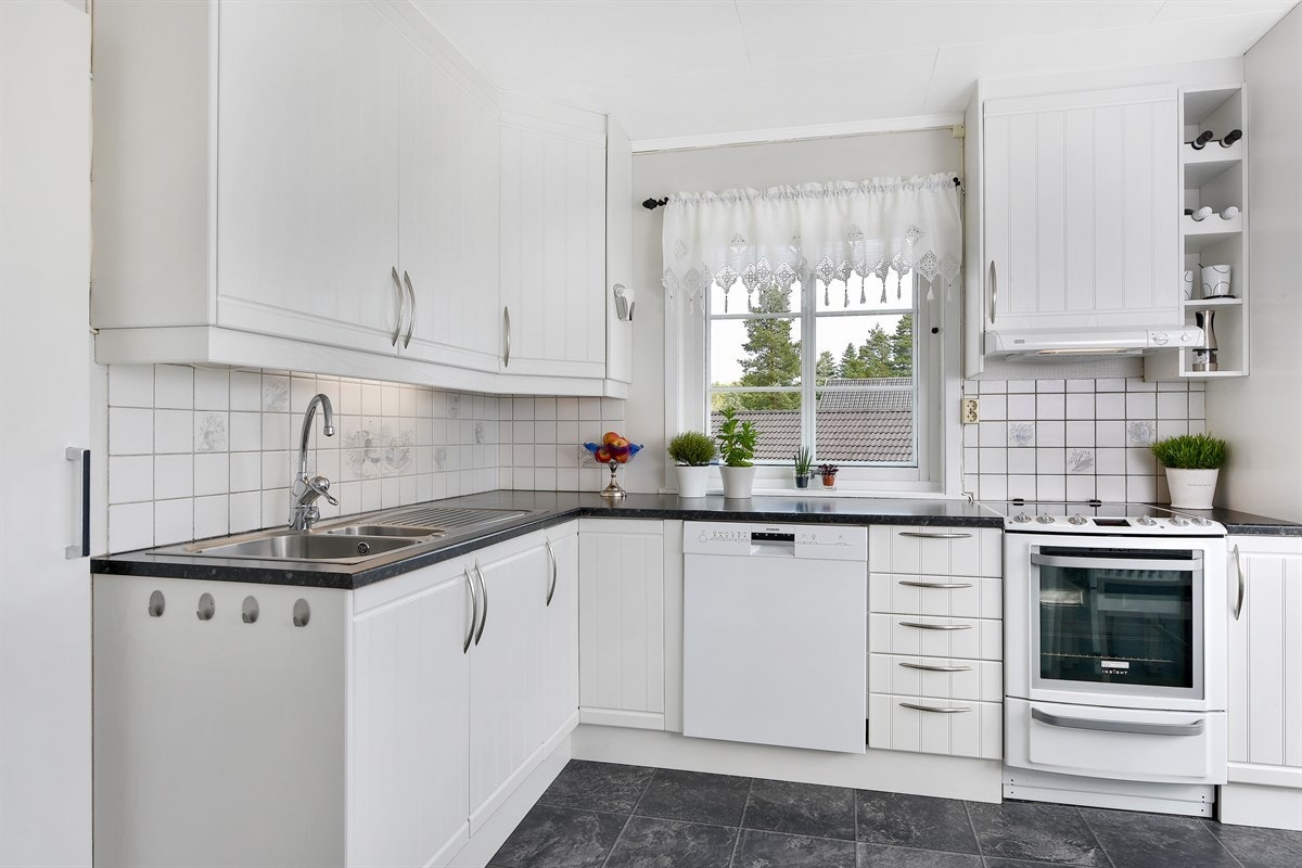 Benkebelysning, fliser og mørke laminatbenkeplater med oppvask- og skyllekum. Galleribilde
