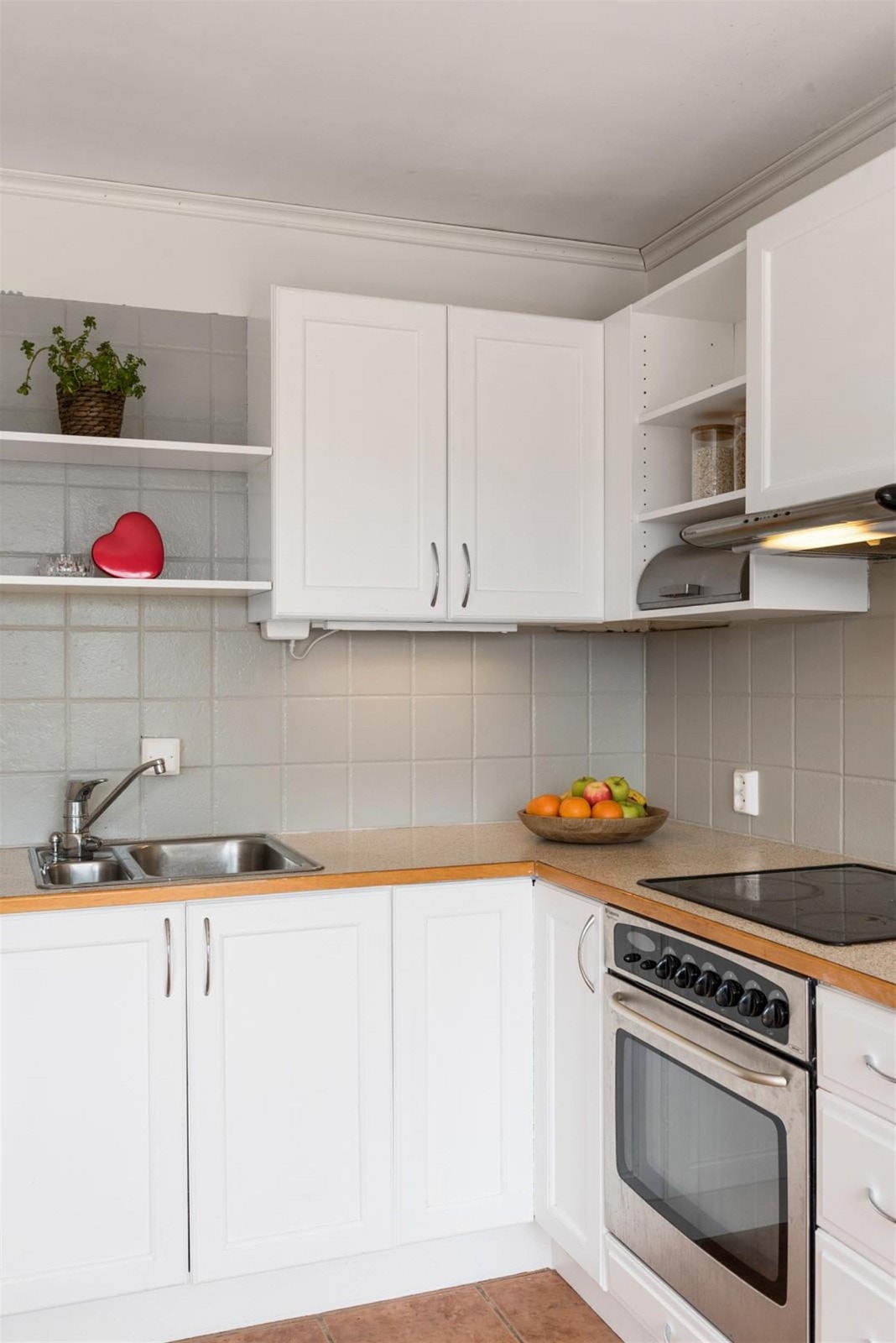 Videre byr kjøkkenet på integrerte hvitevarer. Praktiske fliser over benkeskap. Galleribilde