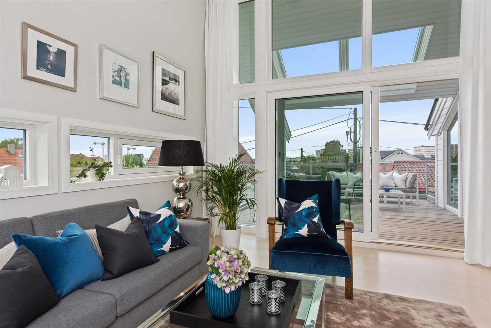 Moderne gulv-til-tak vinduer sikrer rikelig med naturlig belysning i stuen. Galleribilde