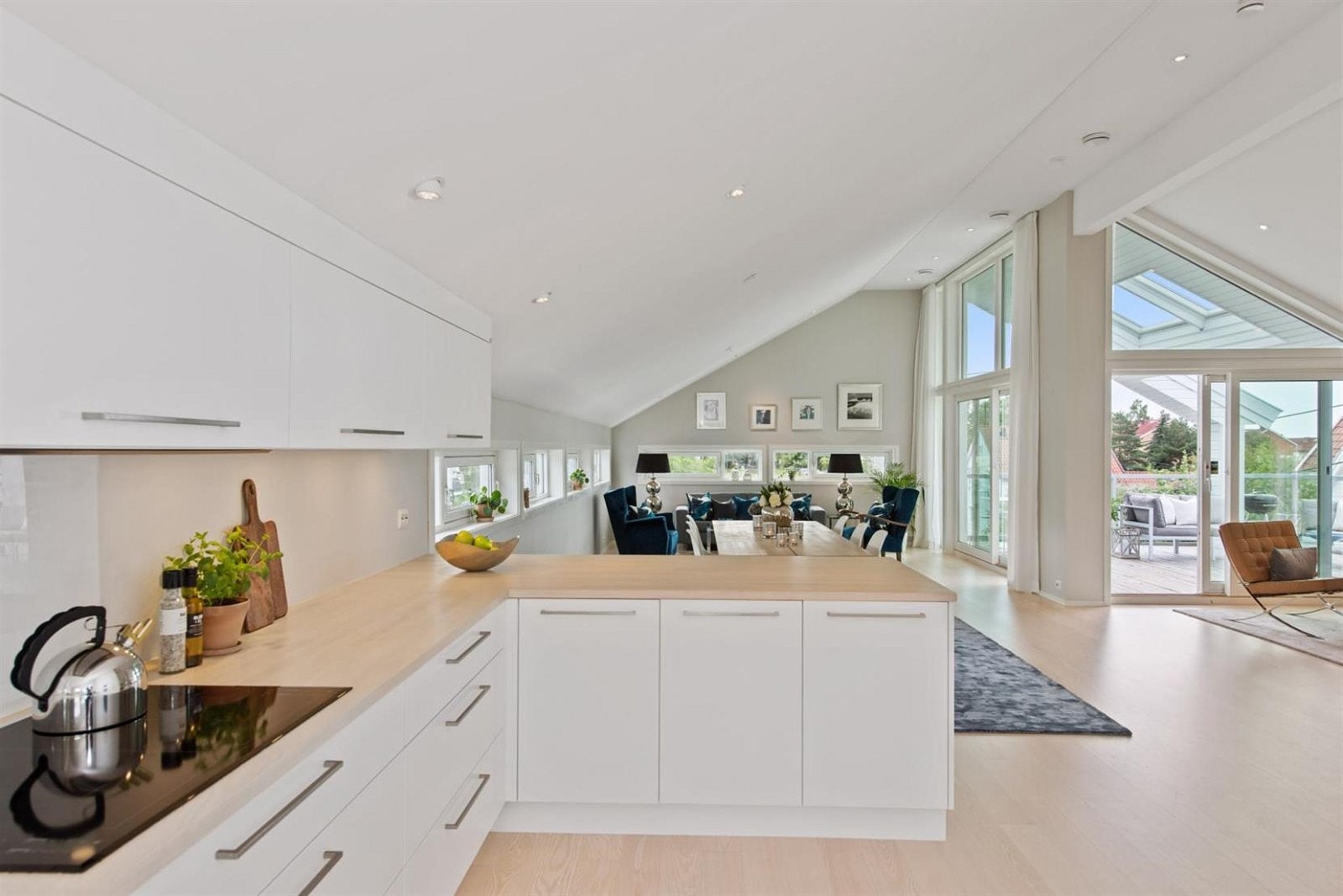 Praktisk og delikat kjøkken, med hvit kjøkkeninnredning fra Hamran. Kjøkkenøyen skaper en fin avskjerming fra stuen. Galleribilde