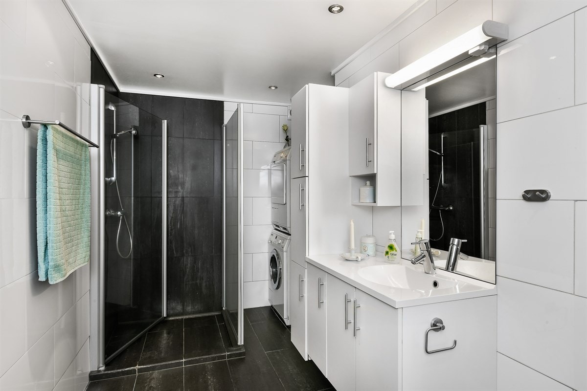 Badet er delikat innredet med gulv- og veggfliser, gulvvarme, mekanisk avtrekk, downlights og vegghengt toalett. Galleribilde