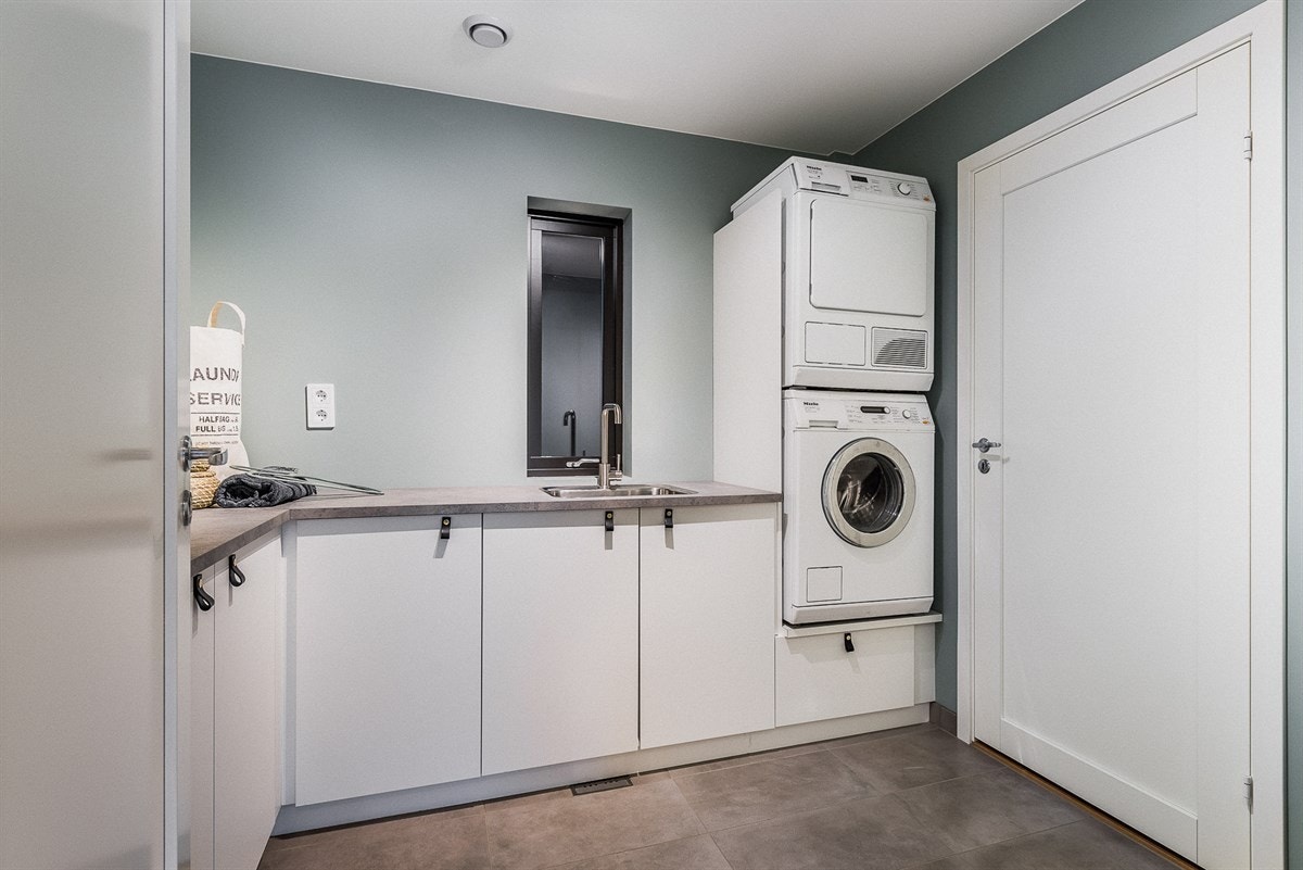 Vegg i vegg med baderommet ligger husets mest praktiske rom. Tilrettelagt for effektive og enkle rengjøringer. Galleribilde