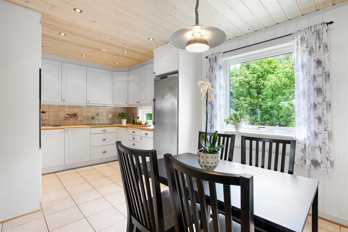 Stilrent kjøkken fra nyere tid i halvåpen løsning mot stue. Moderne downlights i himling. Galleribilde