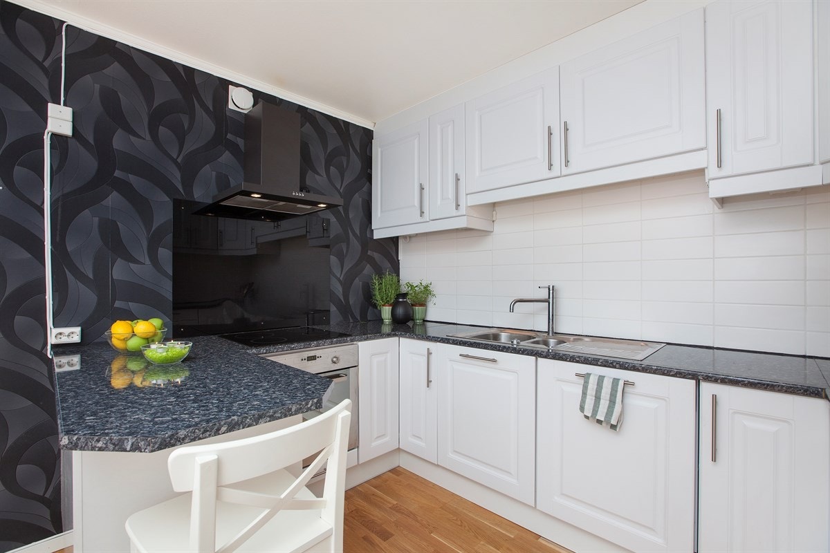 Pent kjøkken fra 2011 med hvit profilert kjøkkeninnredning Galleribilde