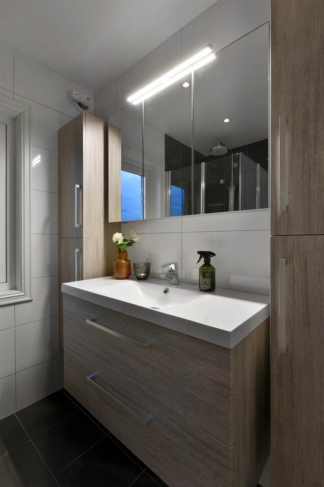 Rommet har polerte, antrasittgrå gulvfliser og hvite veggfliser. Galleribilde