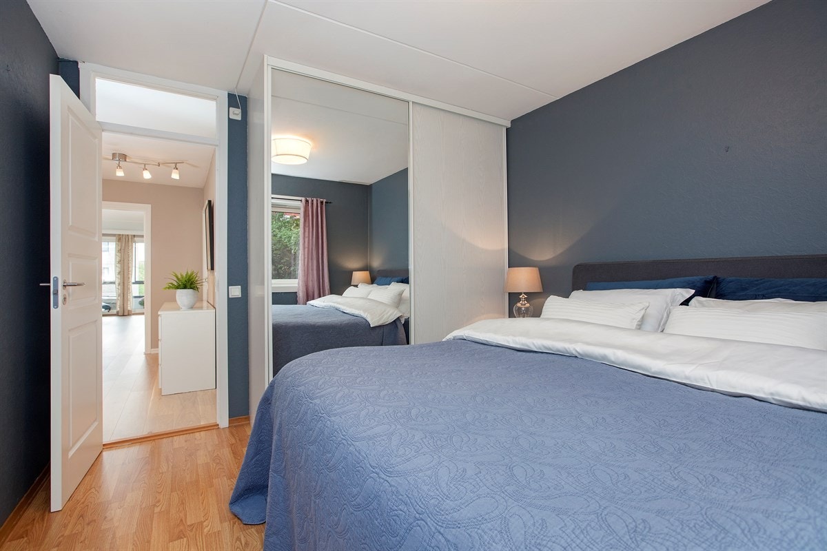 Stille og romslig hovedsoverom utstyrt med skyvedørsgarderobe Galleribilde