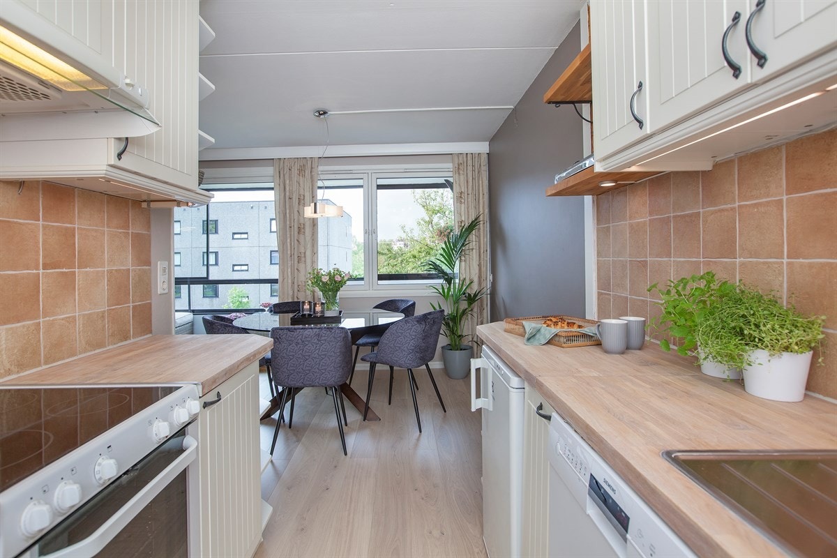 Kjøkkenet ligger i delvis åpen løsning mot stuen Galleribilde