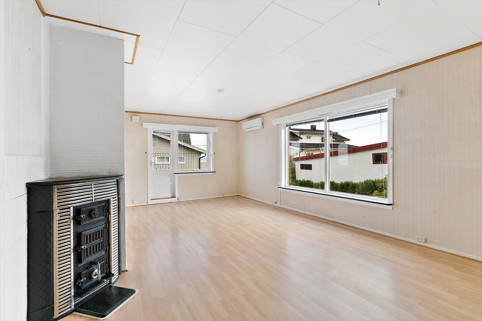 Stuen har eldre vedfyrt ildsted og varmepumpe Galleribilde