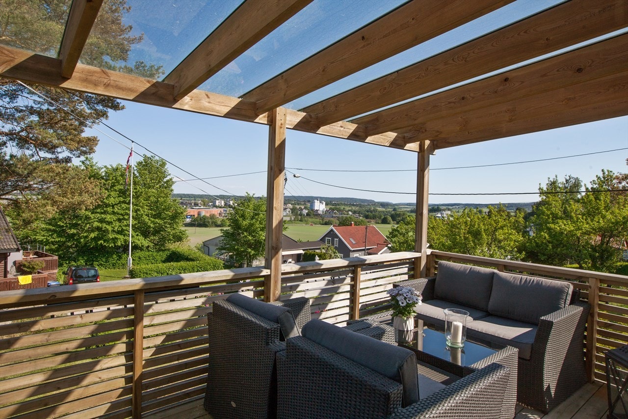 Stor terrasse med glasstak og utgang til hage Galleribilde