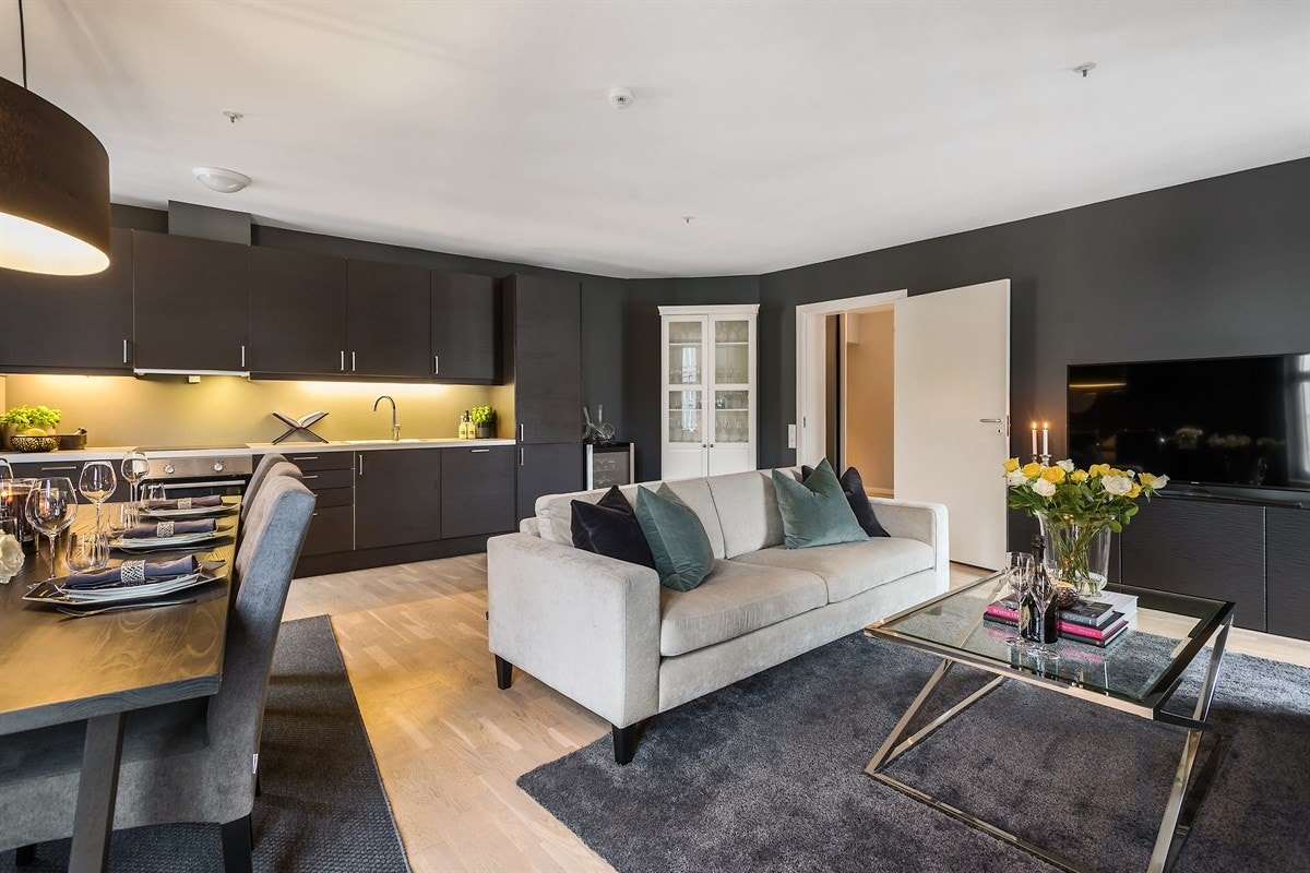 Stuen har en åpen og sosial løsning mot et stilrent kjøkken fra Sigdal. Galleribilde