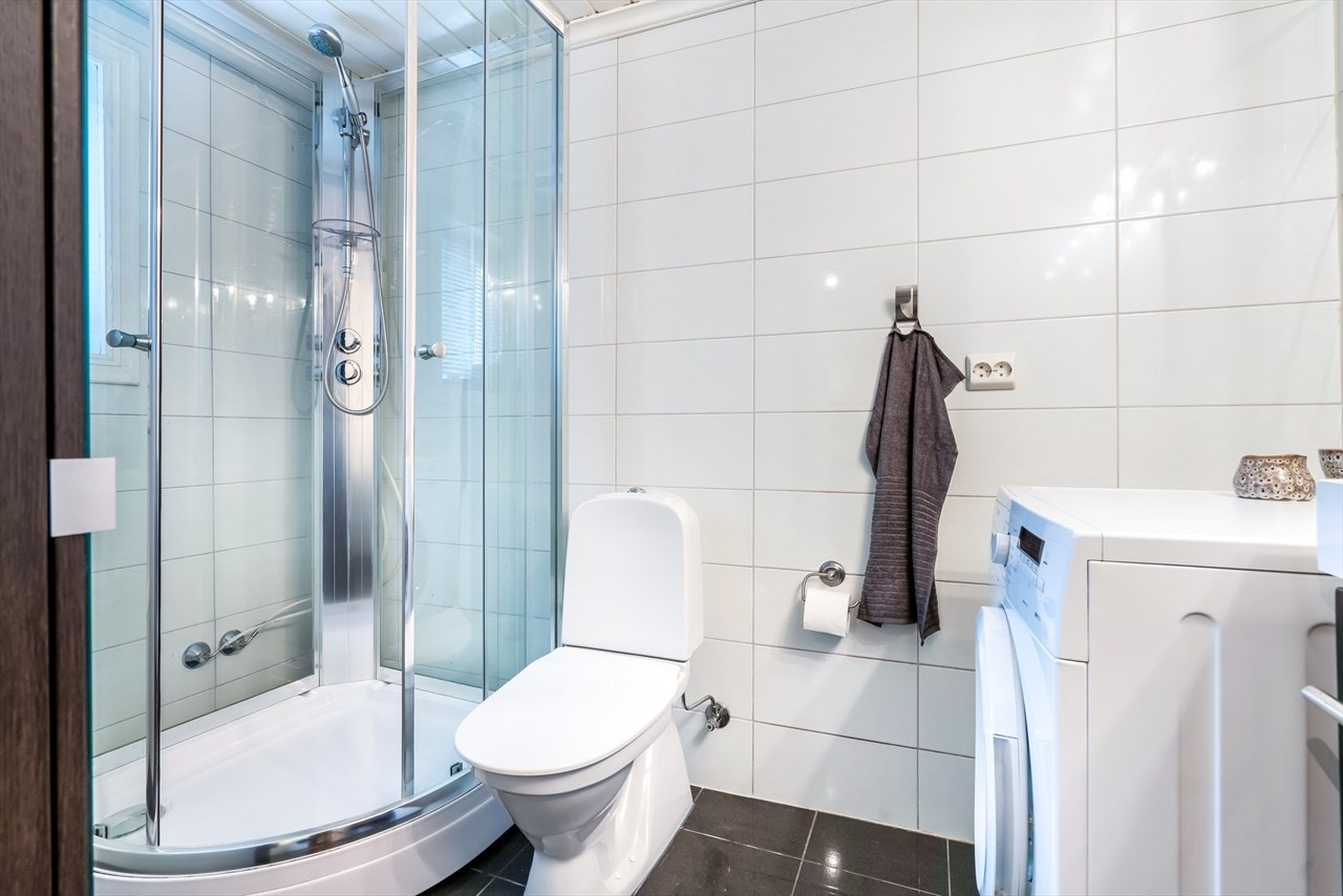 Badet er flott utstyrt med heldekkende servant, dusjkabinett, toalett og opplegg for vaskemaskin. Galleribilde