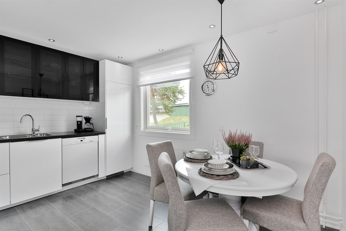 Kjøkkenet er lekkert med downlights, glatte vegger og grå flislaminat på gulv. Galleribilde