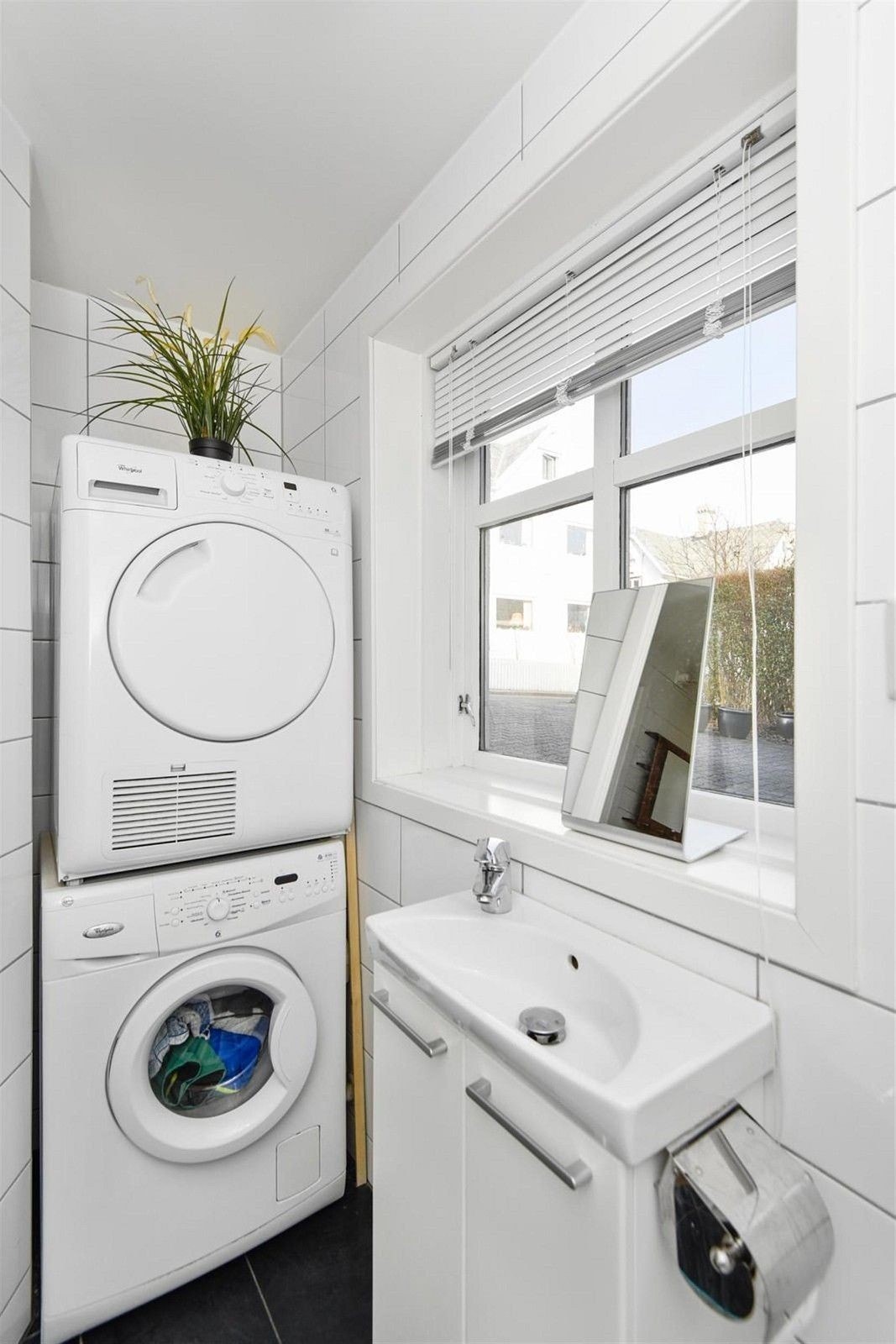 Bad og toilet med vaskemaskine og tørretumbler Galleribilde