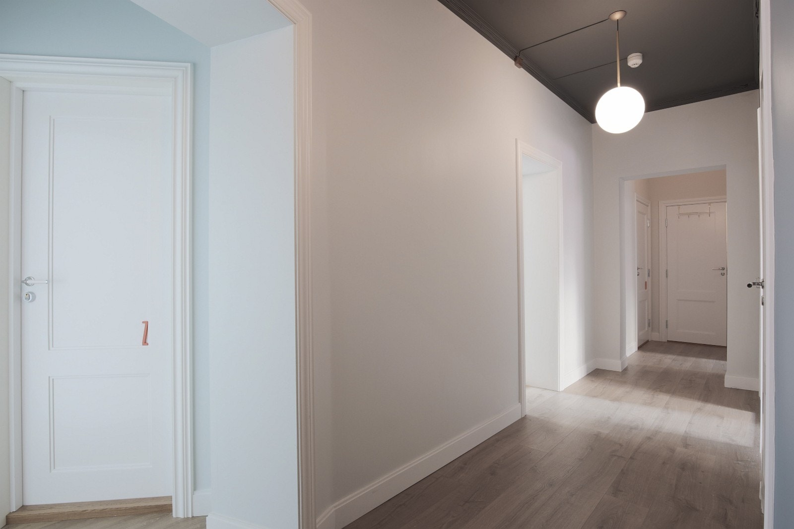 Gang med designlamper Galleribilde