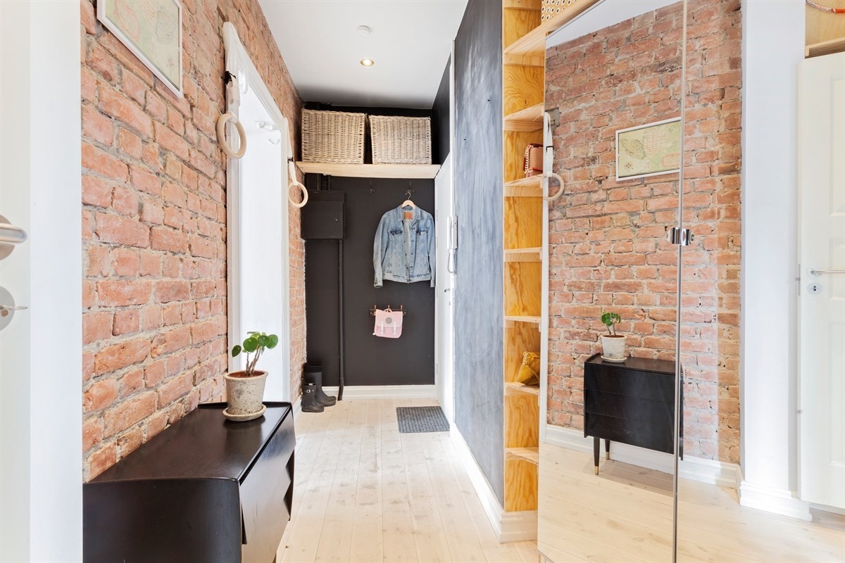 Gang med flotte teglsteinsvegger og flotte kontraster i sort. Gode oppbevaringsmuligheter. Galleribilde