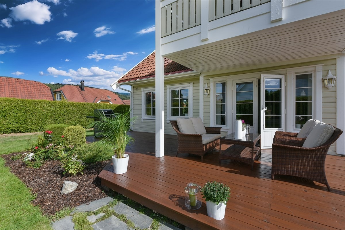 Mellom terrasse og plen er det frodig beplantet med prydbusker, vintergrønt og diverse blomster. Galleribilde