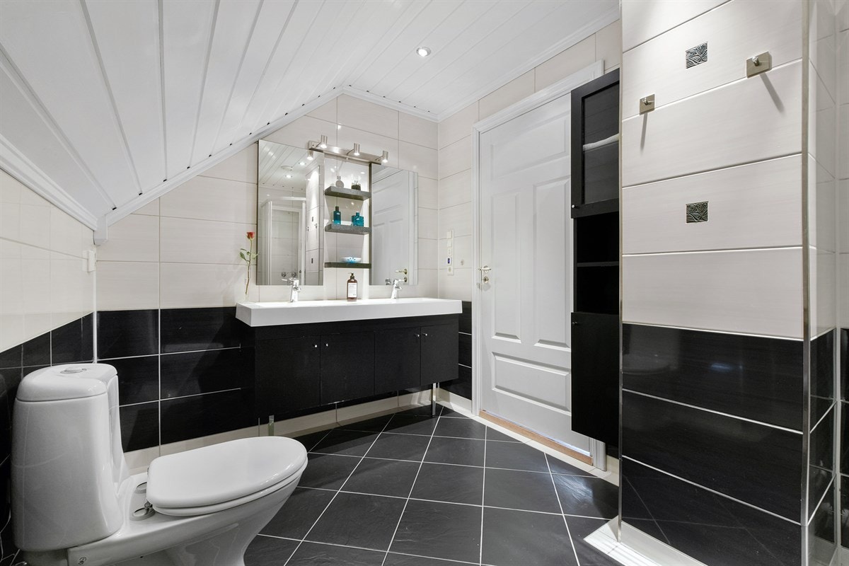Badet i andre etasje har flislagte flater, gulvvarme, downlights og frittstående toalett. Galleribilde