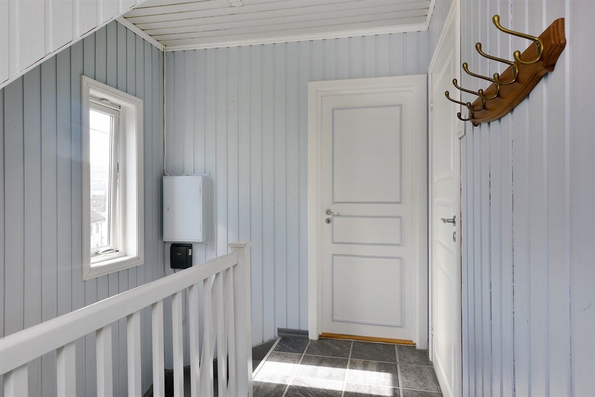 Entreen har laminat med flismønster på gulv, og en knaggrekke for å henge fra seg yttertøy. Galleribilde