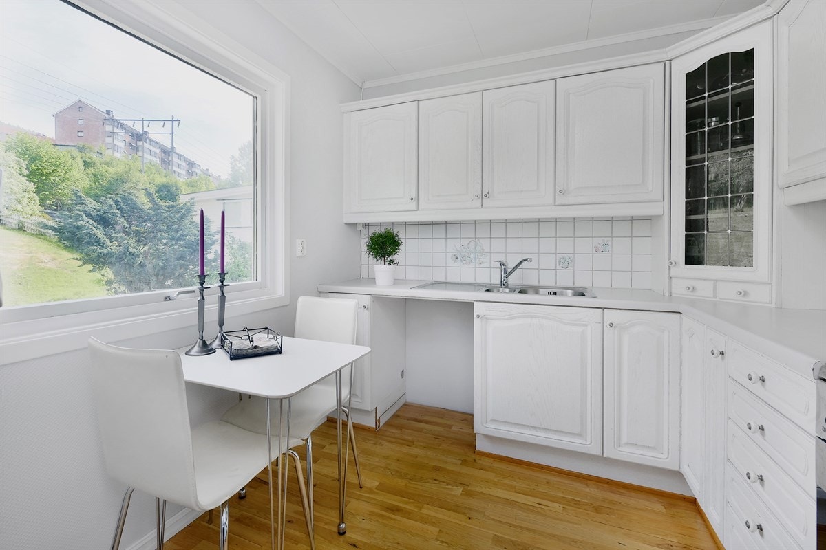 Det koselige kjøkkenet ligger i et eget rom og har plass for et lite frokostbord ved vinduet. Galleribilde