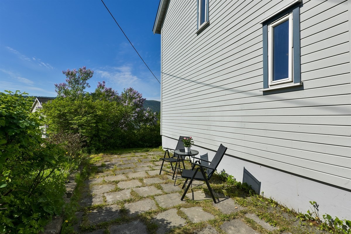 På bakkeplan er det en hellelagt uteplass med plass for sittegruppe. Galleribilde