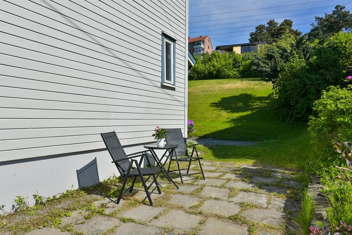 På bakkeplan er det en hellelagt uteplass med plass for sittegruppe. Galleribilde