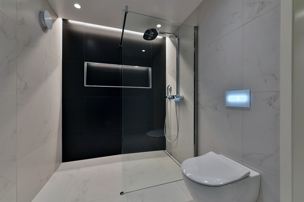 Badet ligger i første etasje - et lekkert og meget påkostet rom fra 2017 med store, lyse fliser på gulv og vegger. Galleribilde