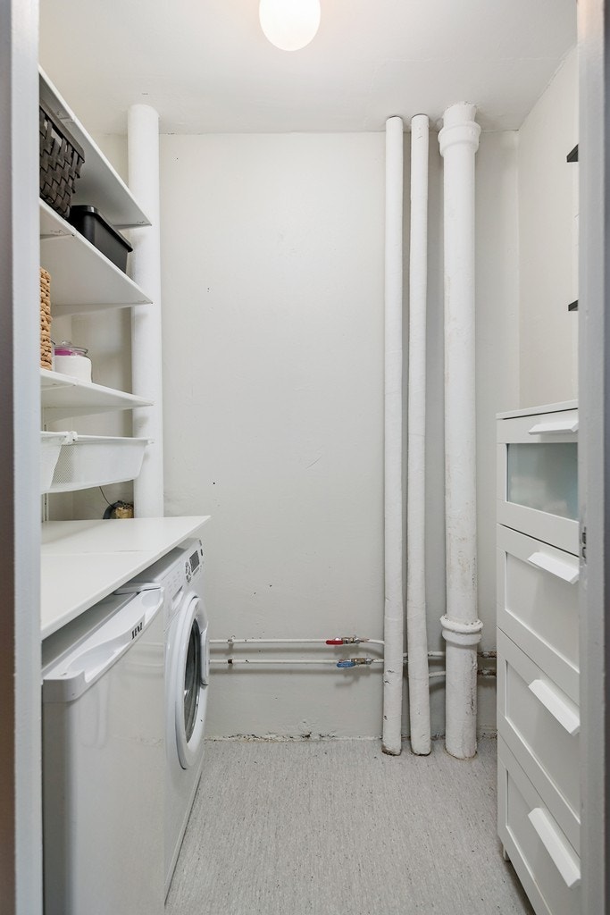 Vaskerommet har belegg på gulv, malte vegger, hylleløsninger, stoppekran og opplegg for vaskemaskin. Galleribilde