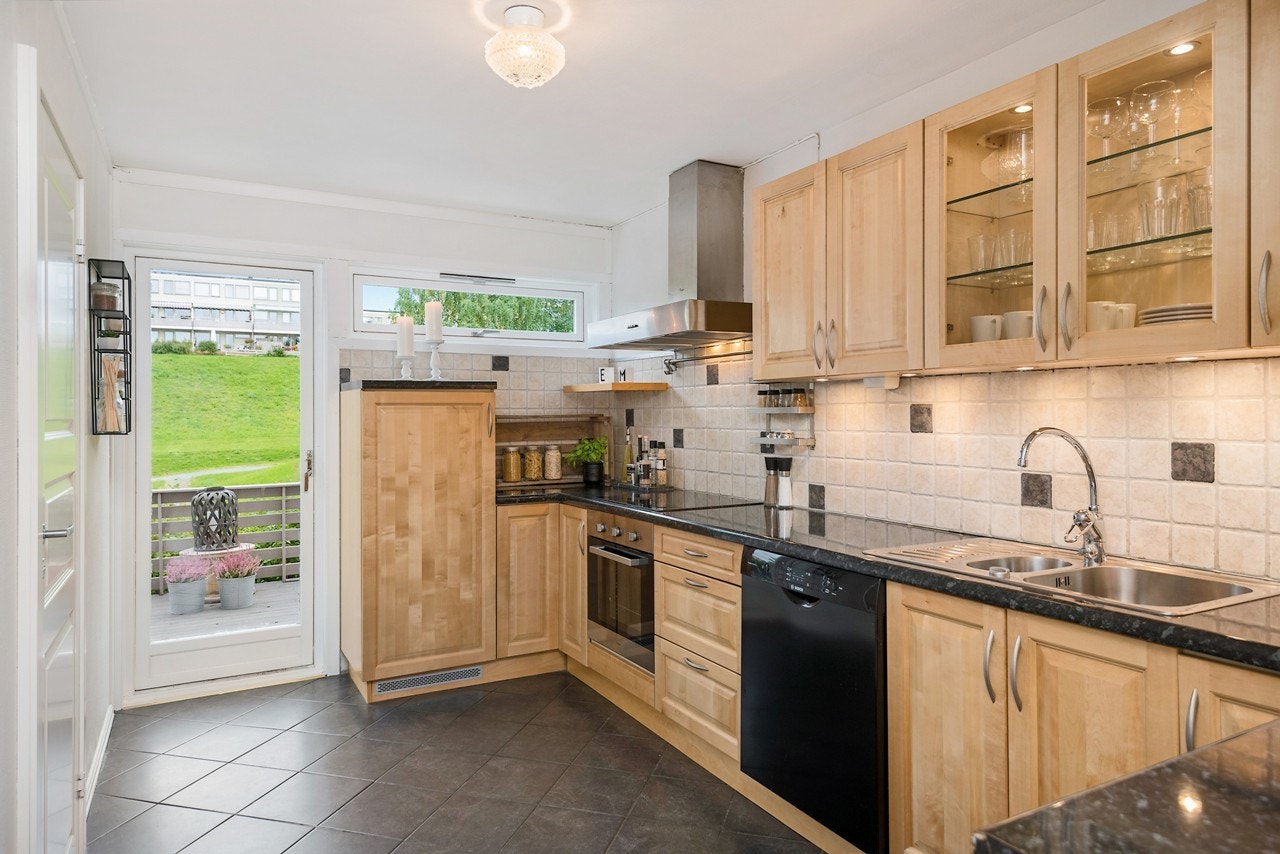 Kjøkkenet er stort og fint, med mørke fliser på gulv, lysmalte vegger og lun gulvvarme. Galleribilde