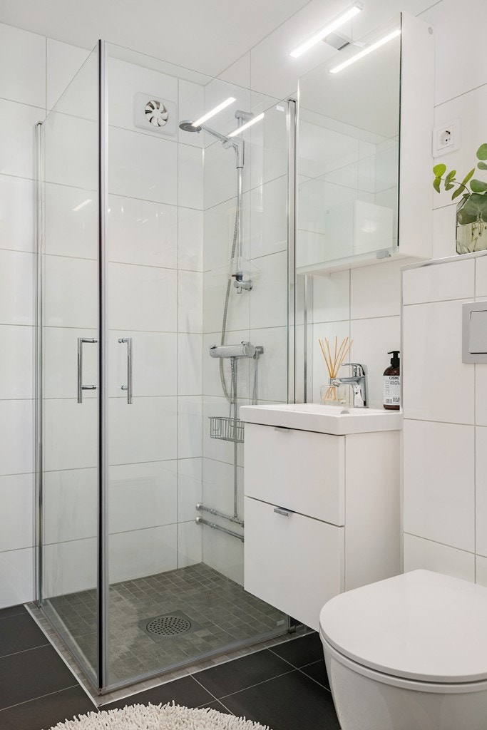 Badet ble renovert i 2017 og har mørke fliser på gulv, hvite fliser på vegger og lun gulvvarme. Galleribilde