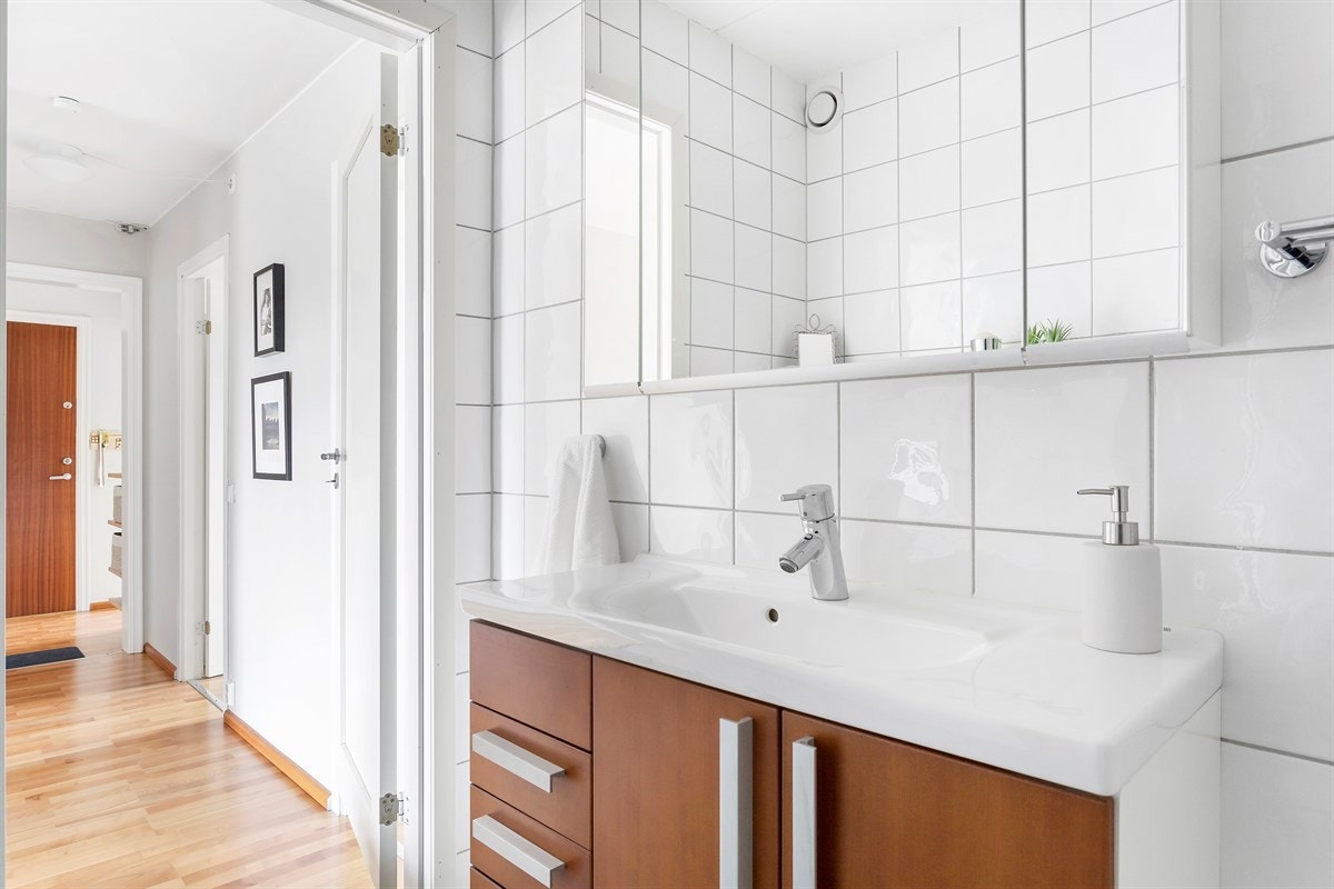 Badet er utstyrt med servant i skapinnredning, speilskap, hjørnedusj med svingbare glassdører og vegghengt wc. Galleribilde