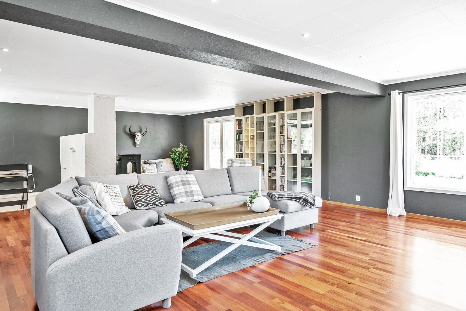 Store vindusoverflater og verandadør i glass sørger for godt lysinnslipp og gjør stuen til et åpent og luftig rom. Galleribilde