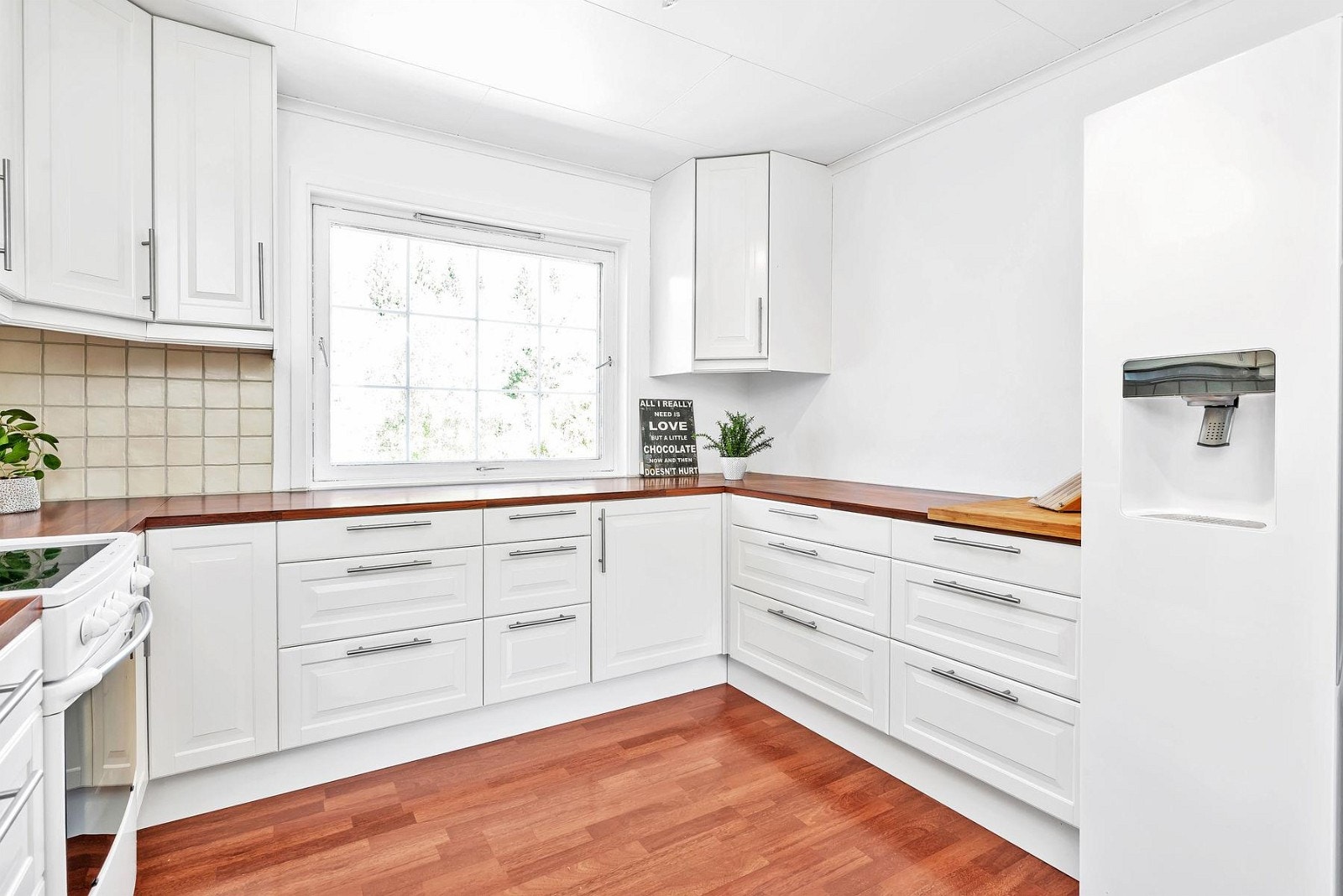 Lys og pen kjøkkeninnredning med hvite fronter. Galleribilde