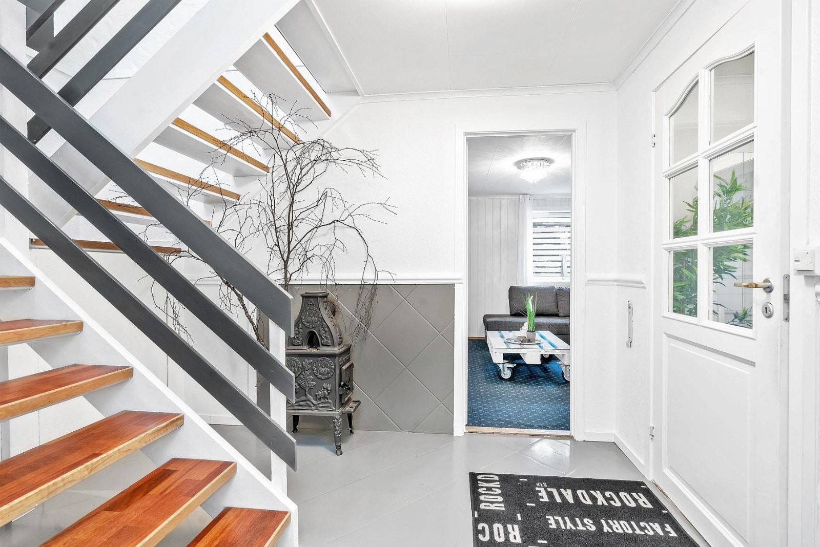 Koselig gang med peis. Adkomst til et av boligenes soverom som i dag blir brukt som kjellerstue. Galleribilde