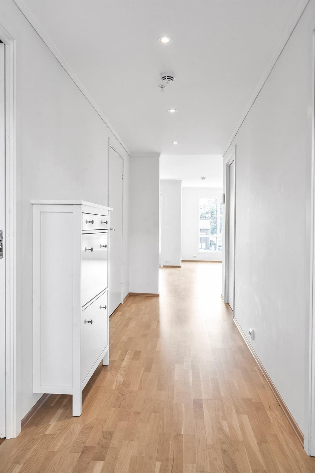 Innbydende gang med plass til yttertøy og sko. Spotter i tak og adgang til leilighetens resterende rom. Galleribilde