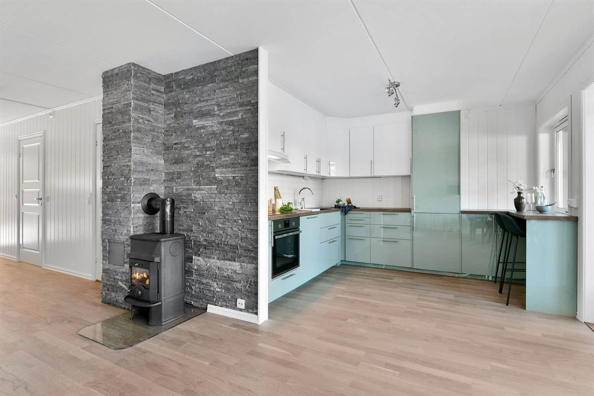 Stuen har peisovn som sørger for effektiv oppvarming og ekstra hygge. Galleribilde