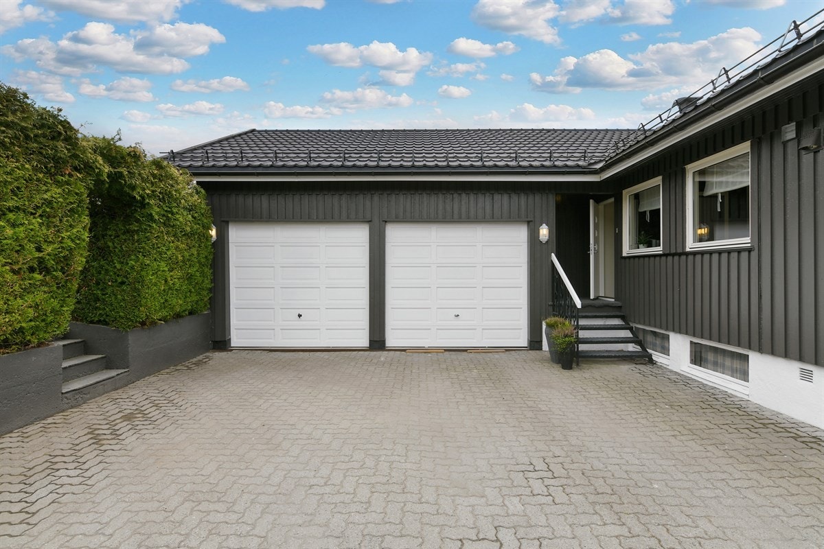 Det er parkering i en stor dobbelgarasje og på en steinbelagt gårdsplass med plass til menge biler til både hoveddelen og utleiedelen. Galleribilde