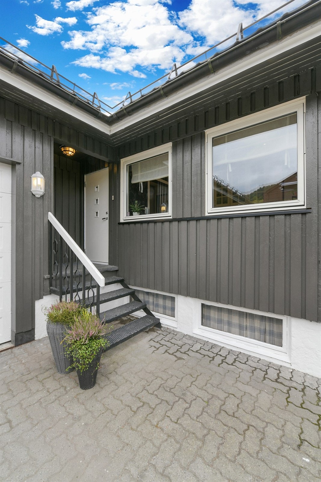 Via en stor, ryddig og steinlagt gårdsplass kommer vi til det overbygde inngangspartiet til hoveddelen av eneboligen. Galleribilde
