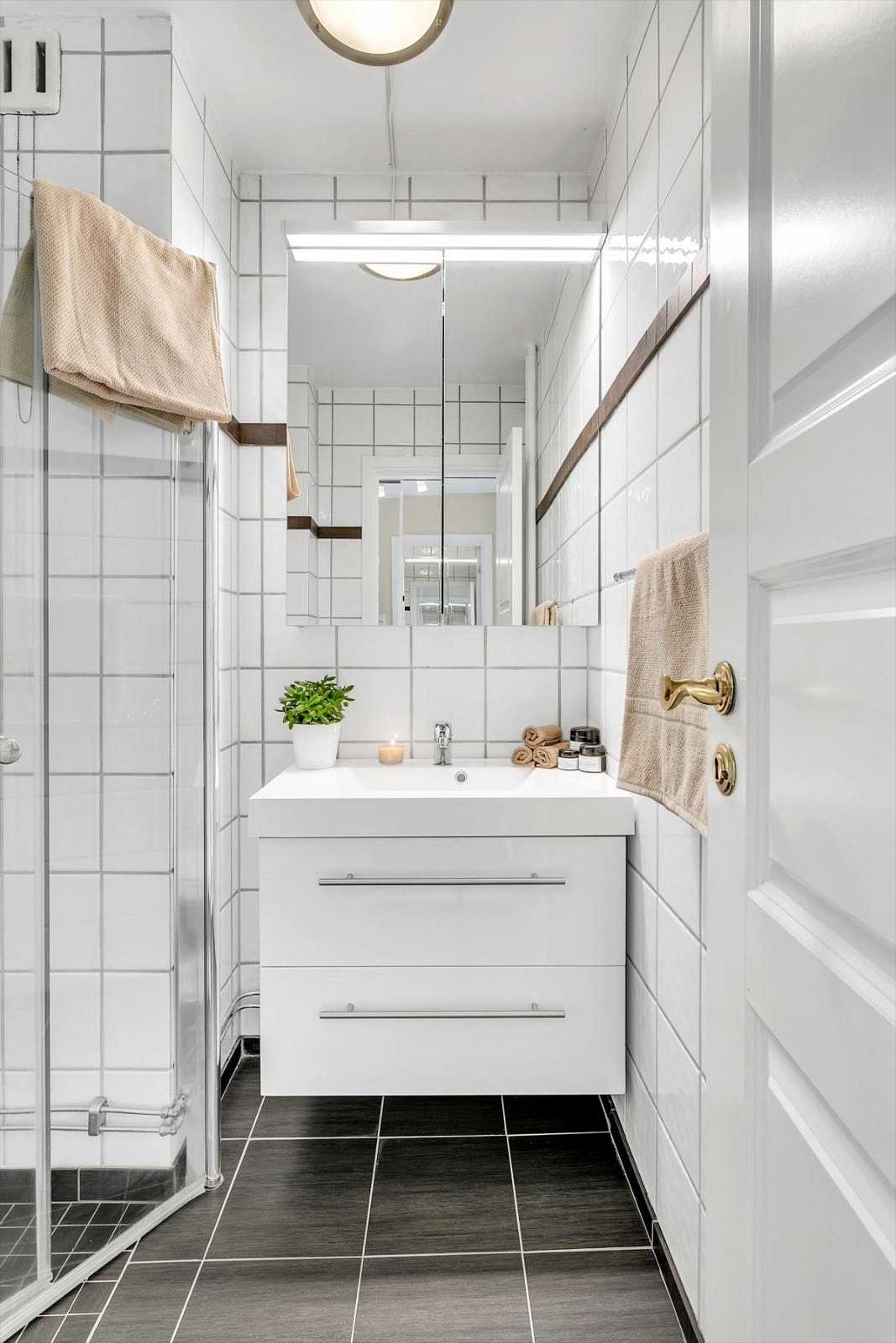 Pent bad med fliser på gulv og vegger. Badet ble modernisert i 2016 hvor det ble lagt nye fliser på eksisterende fliser. Galleribilde