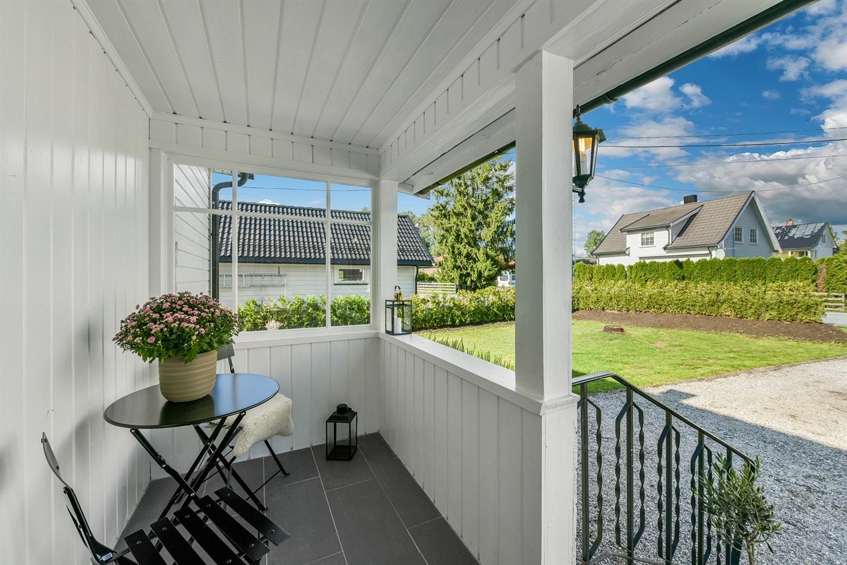Boligen har adkomst via trapp og overbygd, flislagt inngangsparti med plass til kafémøbler. Galleribilde