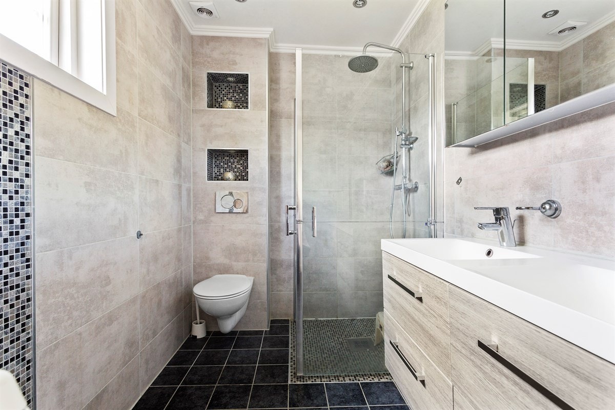 Pent bad med dobbel baderomsinnredning med underskap og stort speilskap. Galleribilde