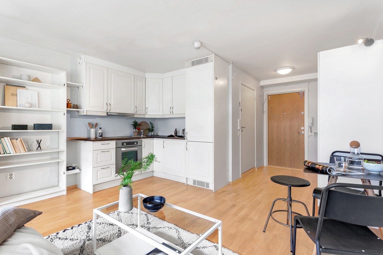 Lyst kjøkken med hvite, profilerte fronter og håndtak i stål. Galleribilde