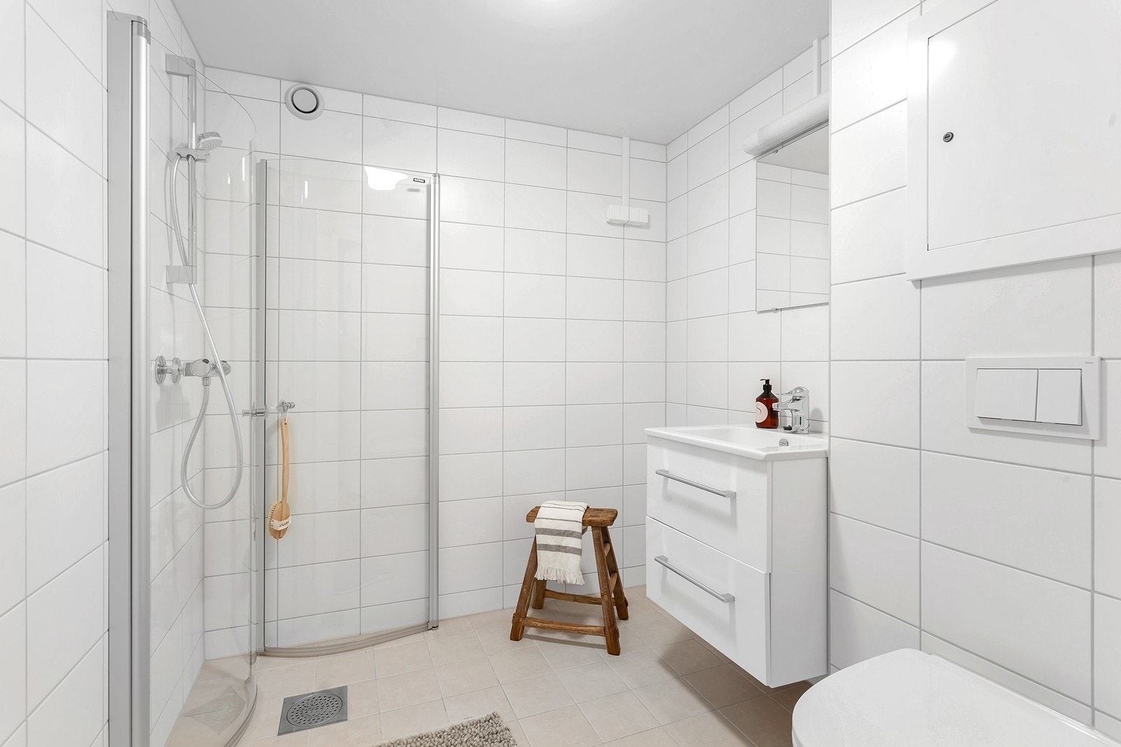 Nytt og moderne, flislagt bad med dusj med foldbare glassdører og vegghengt toalett. Det er også opplegg for vaskemaskin. Galleribilde