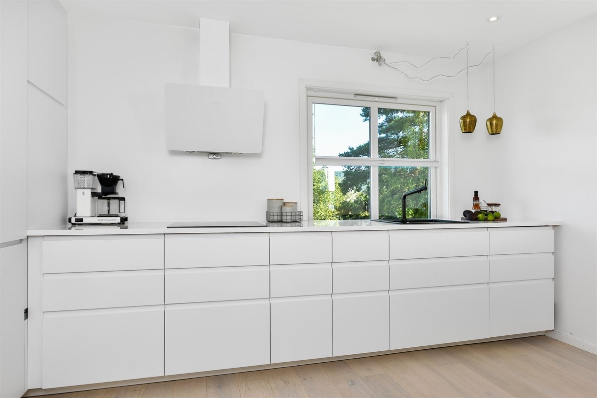 Fra kjøkkenbenken bidrar et vindu til å skape en hyggelig arbeidsplass. Galleribilde