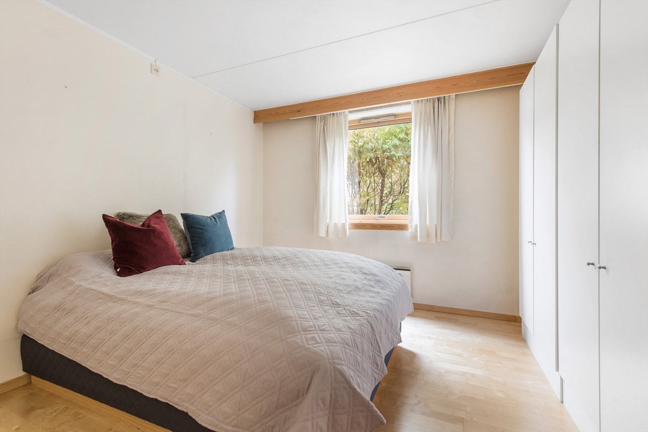 Romslig soverom med stor garderobeløsning og plass til dobbeltseng og nattbord Galleribilde