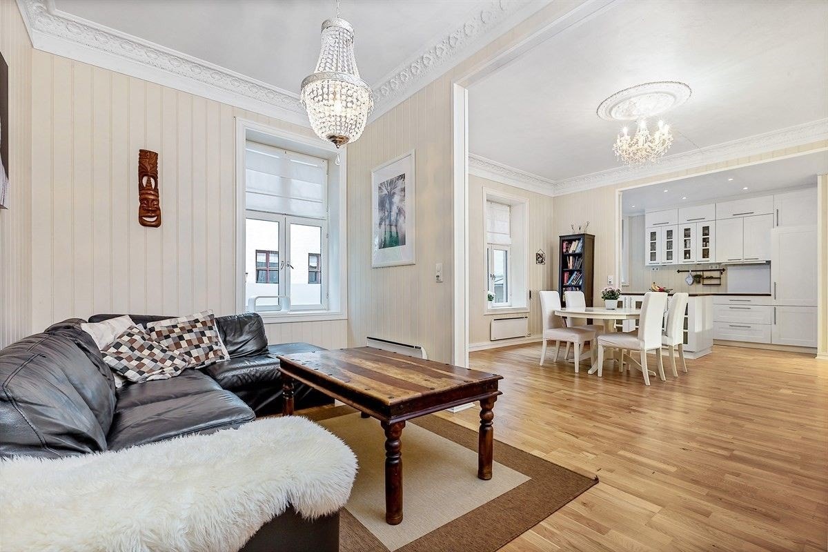 Romslig stue med plass til sofa og tilhørende møblement samt klassisk stukkatur og rosett Galleribilde