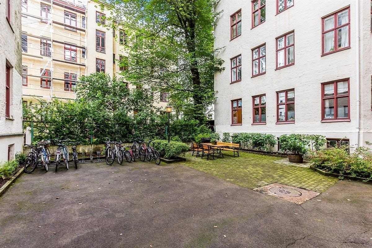 Bakgård med beleginingsstein og beplantning, samt sittegruppe og sykkelparkering Galleribilde