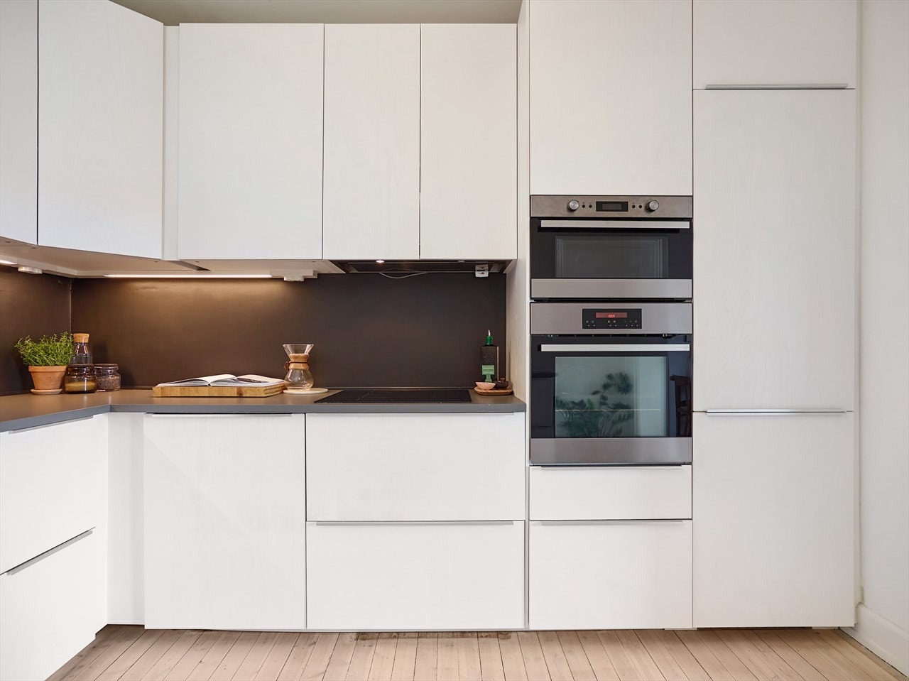 Tidsriktig innredning med hvite, glatte fronter og benkeplate i laminat. Galleribilde