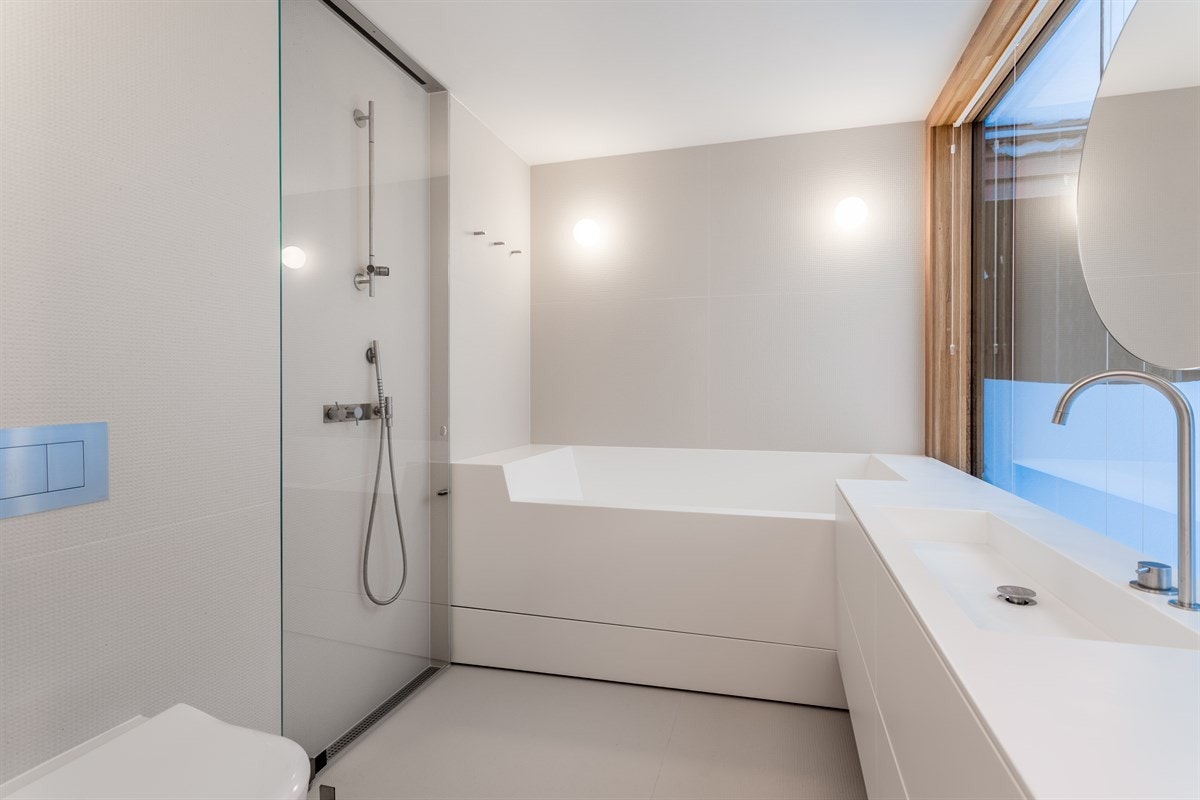 Dusjløsning med utfellbar glassvegg, vegghengt WC samt baderomsinnredning og badekar Galleribilde